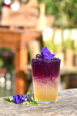 Herbal drink on the old wood texture,natural patterns with knots and nail holes. Anchan juice make, Pea flowers, lemon and syrup. The concept of herbal water to cure thirst. Vertical image