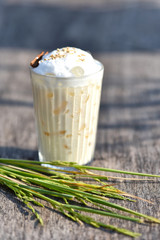 Rice milk or Creamy rice pudding sprinkled with cinnamon Herbal drink on the old wood...