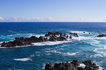 Waves crashing on volcanic black rocks in the Atlantic Ocean (Porto Moniz, Madeira, Portugal)