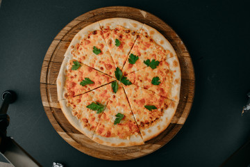 Top view on homemade italian four cheeses pizza. Pizza on rustic wooden background with tomato, cheese, basilic. Copy space. Traditional italian cuisine. Flat lay picture for recipe or menu