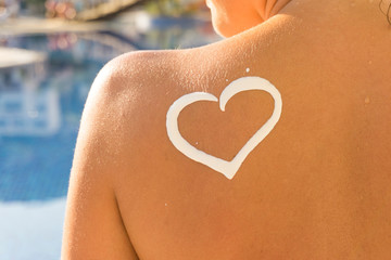Woman with heart shaped sun cream