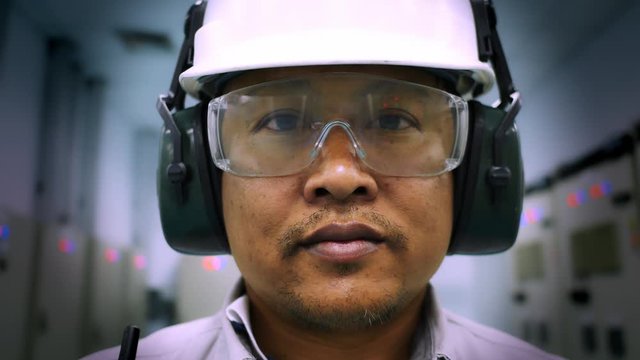 Portrait of Worker man wearing a safety helmet and safety goggles stay in petroleum refinery plant