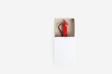Tiny fire extinguisher inside a white match box, top view, isolated on white
