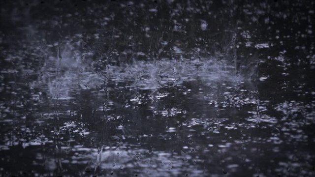Heavy rain shower downpour cloudburst rainfall behind the glass.