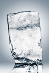 Block of clear ice on reflective surface. Clipping path included.