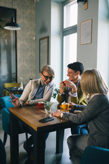 mid aged woman friends enjoying time drinking coffee in cafe