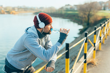 young man jogger drinking water , jogging outdoor