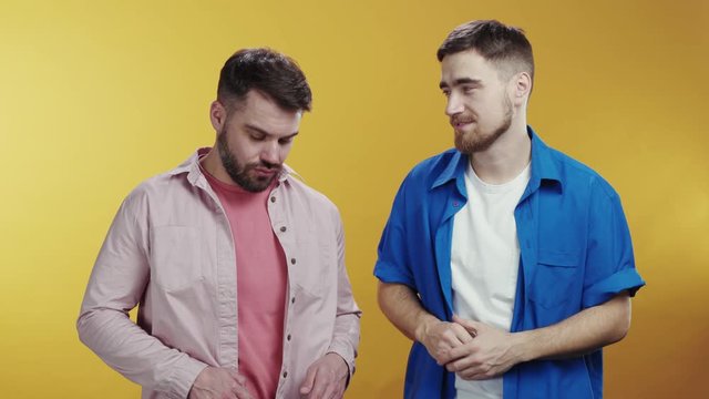 Male best friends talking lifestyle things together isolated on background. Jealous blonde woman kick out a man choosing her boyfriend embracing smile at camera. Interpersonal relationship.