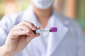 Asian male doctor holding Covid-19 Blood Sample on White Background