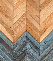 Wooden wall with herringbone pattern made of blue and brown planks.