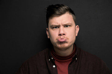 Obraz premium Portrait of young grimacing man isolated on gray background