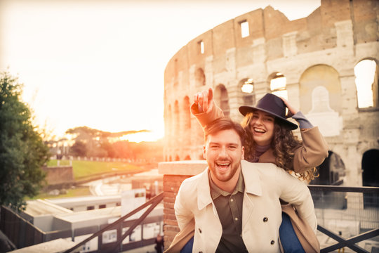 Happy couple of travelers having fun, girl pointing forward. Happy tourists visiting famous monuments. Honeymoon trip, tourism, love vacation and vacation trip concept - Image