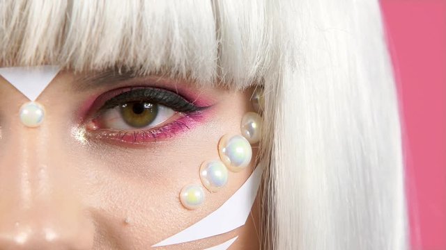 half face, very close-up, model girl&rsquo;s eye. fashion concept. Professional creative makeup. pink eye shadow. long eyelashes. black eyeliner. beauty salon. girl from the future