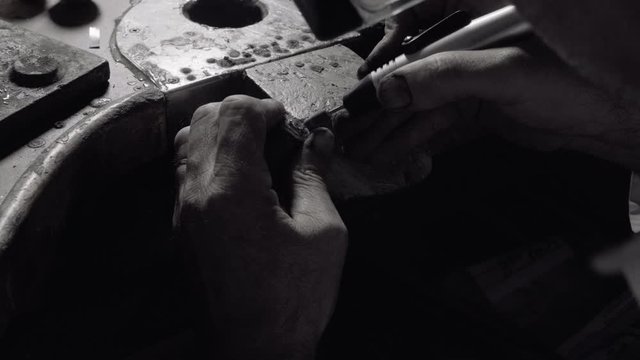 Man crafting a diamond ring jewel with his tools 
