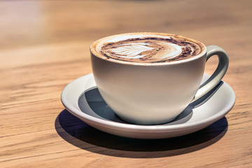 A ceramic cup of cappuccino close up, no people, profile view.