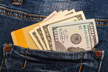 Dollar bills stick out of a jeans pocket with a golden card. Two types of cash material and virtual.