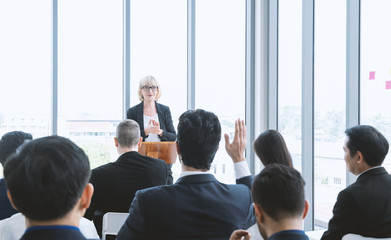 Fototapeta premium Beautiful of business woman is speaking on conference. Seminar of business model and inspiration concept with the audience put hand up to ask the question from topic.