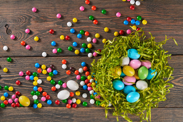 Fototapeta na wymiar Colorful easter eggs in nest and candies.