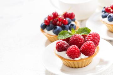 mini tarts with cream and berries and white background