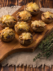 baked mushrooms with cheese on a wooden board.