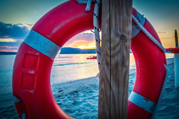 Life buoy by the sea in Alghero shore at sunset