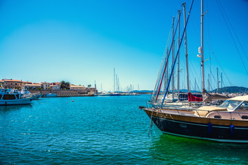 Boats in Alghero harbor on a clear springtime day