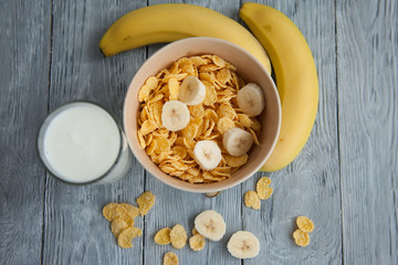 Fototapeta premium Healthy breakfast with glass of milk, bananas and corn flakes