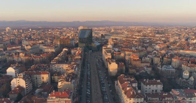Boulevard in Sofia Bulgaria with city traffic and modern architecture building at sunset