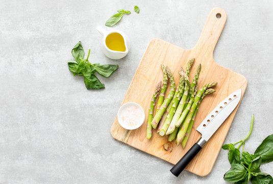 Asparagus cooking concept, top down view on a cutting board with fresh bunch of asparagus, lying down on a kitchen table