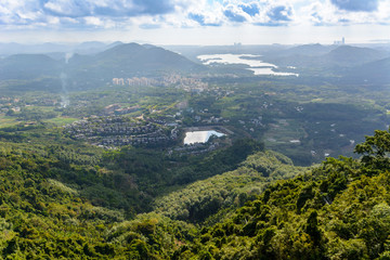 Fototapeta na wymiar Panoramic view to mountains, tropical forest, Yanoda Park and Sanya city. Rainforest cultural tourism zone Yanoda, Hainan, China.