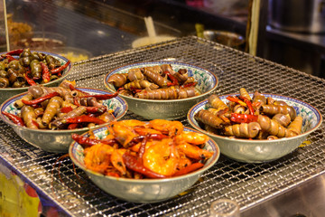 Chinese street food. Street trading. Chinese kinds of fresh seafood at an asian seafood market in Sanya, Hainan province, China. Inscription: name food.