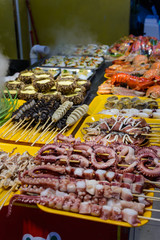 Chinese street food. Street trading. Chinese kinds of fresh seafood at an asian seafood market in Sanya, Hainan province, China. Inscription: name food.