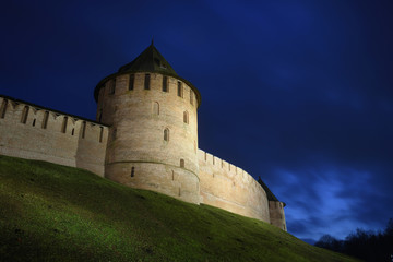 Night view from below on towers of an ancient fortress against the background of a night blue sky. Veliki Novgorod. Fedorovskaya and Metropolitan towers. Veliky Novgorod. Novgorod Kremlin. Old fortres