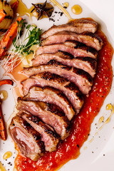 Delicious sliced grilled duck breast with fresh sauce.  closeup of professionally prepared food. top view from above