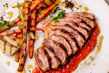 Delicious sliced grilled duck breast with fresh sauce.  closeup of professionally prepared food. top view from above