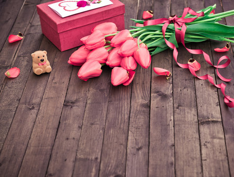 Flower. Tulip. Spring flowers. Bouquet of Red Tulips with Gift box on Dark wooden background. Greeting for Women, Mothers Day, Valentine's day. Copy space