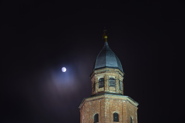 Ancient tower against the background of the night sky and the full moon. Veliky Novgorod. Kremlin. Kokuy tower