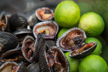 Fresh black shells with limes at a local market