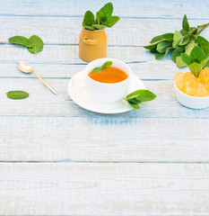 Mint Tea in White Mug. Herbal Tea of Fresh Green Mint Leaves Cup and Crystal Sugar on Rustic wooden Table. Alternative medicine. Traditional herbal therapy. Phytotherapy Medicinal Herbs. Copy space