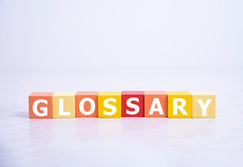 Glossary - word from wooden blocks with letters, alphabetical list with words meanings dictionary...