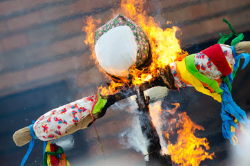 Burning effigies straw Maslenitsa in fire on traditional slavic national holiday Shrovetide.