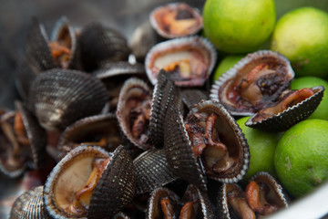 Fresh black shells with limes at a local market