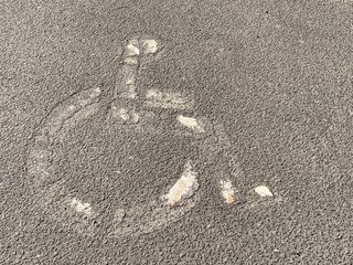 Faded white handicap disability parking symbol on asphalt © Lost_in_the_Midwest
