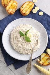 The concept of classical Jewish cuisine. Snack forshmak. A dish of herring, eggs and onions with white bread croutons on a light plate. Background image, copy space