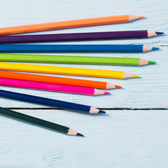 Obraz premium multicolored pencils on blue wooden background