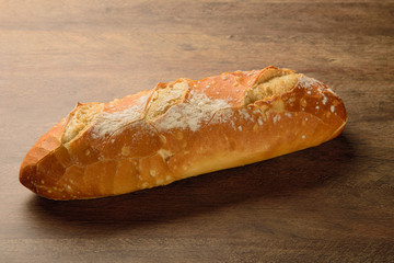 Natural baguette on the wooden table.