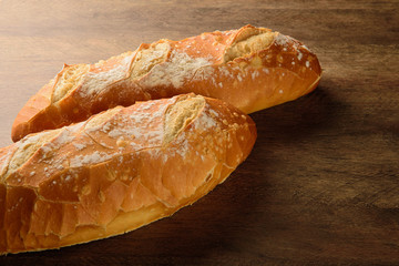 Natural baguette on the wooden table.