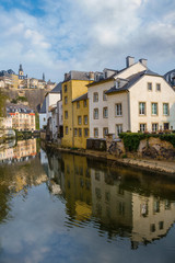 Fototapeta na wymiar View of colorful living houses. Reflection in the Alzette river. Grund, Luxembourg. Beautiful spring nature. 