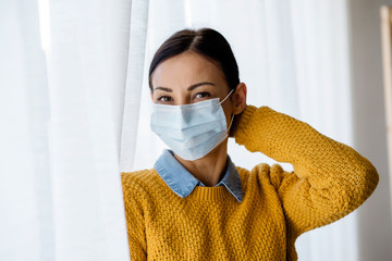 Portrait of young Asian woman,  wearing a medical surgical disposable face mask to prevent infection, virus, air pollution