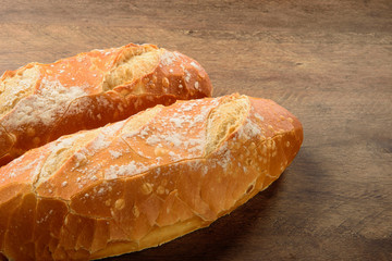 Natural baguette on the wooden table.